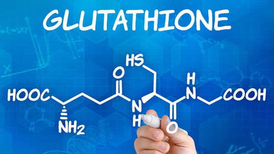 Glutathione molecular structure with a hand holding a pen on a blue background.