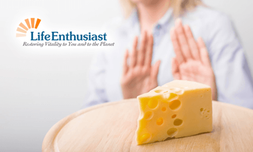 When Food Hurts: A person rejecting cheese on a wooden board, highlighting dietary sensitivities.