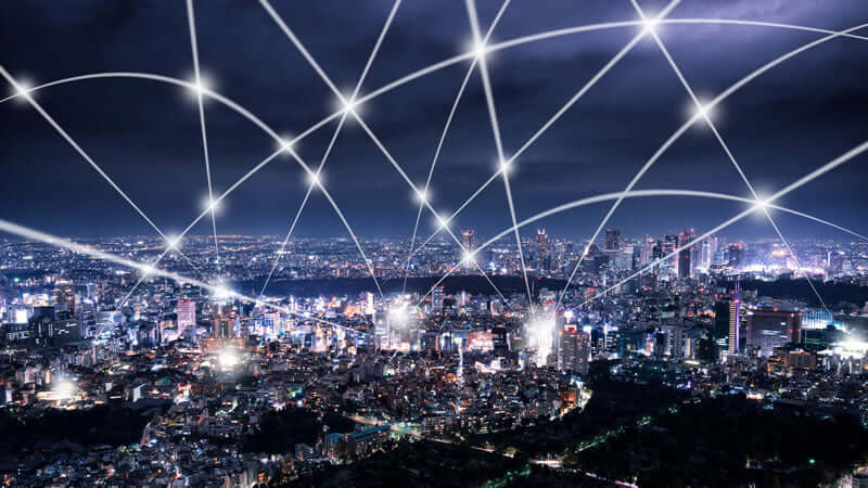 Night cityscape with glowing lines representing EMFs and connectivity in urban areas.