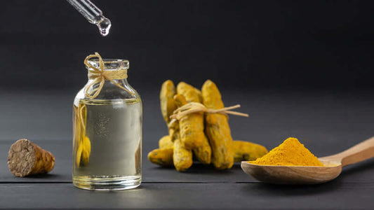 Turmeric and Mental Health - a bottle of turmeric oil and fresh turmeric root with powdered turmeric.