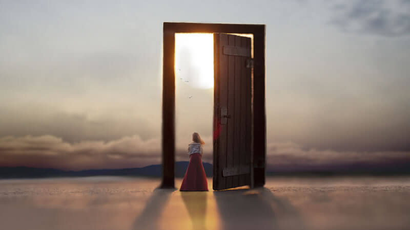 ORMUS Advise by Barry Carter, A woman standing at an open door, symbolizing new beginnings and opportunities in the sunset.