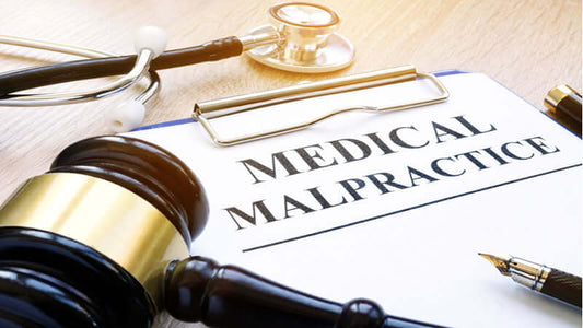 Aspartame Lawsuit, Gavel, stethoscope, and clipboard with text 'MEDICAL MALPRACTICE' on a desk.