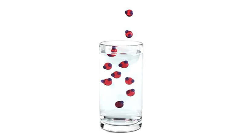 Glass of water with red berries illustrating hydrogen as therapeutic antioxidant benefits.