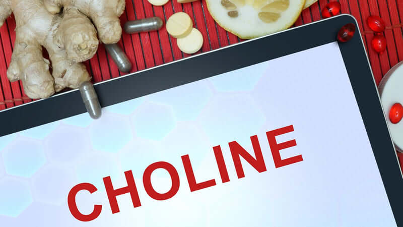 Close-up of a tablet displaying the word CHOLINE surrounded by supplements and herbs.