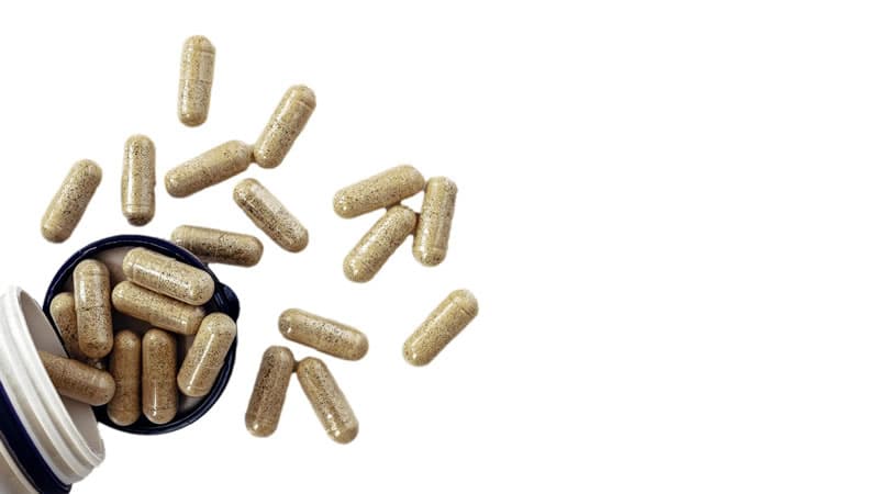 A bottle spilling capsules, representing the topic of Individual Enzymes Basics.
