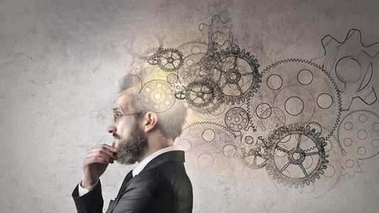 A man in a suit with a thoughtful expression, gears illustrated around his head, symbolizing mental processes for Book The Field.