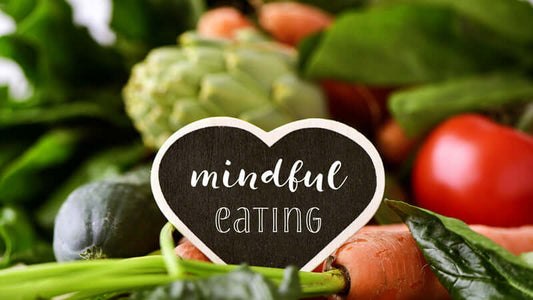 A heart-shaped sign reading 'mindful eating' surrounded by fresh vegetables, promoting healthy choices in Fighting Chronic Pain With Food.