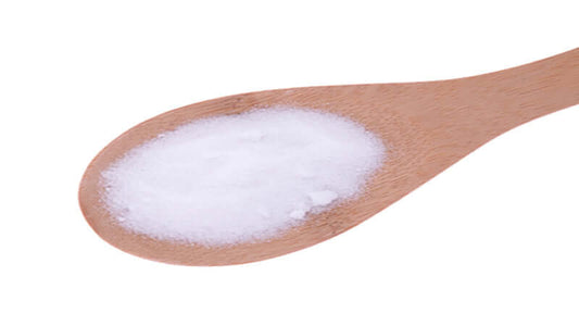 MSM methylsulfonylmethane powder on a wooden spoon, highlighting its natural form.