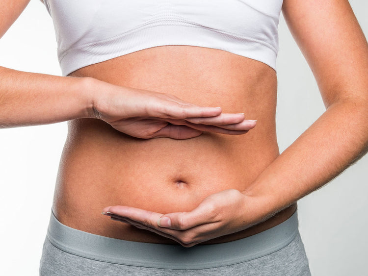 Image of a woman holding her stomach, representing digestive health and Microbiome Restoration.