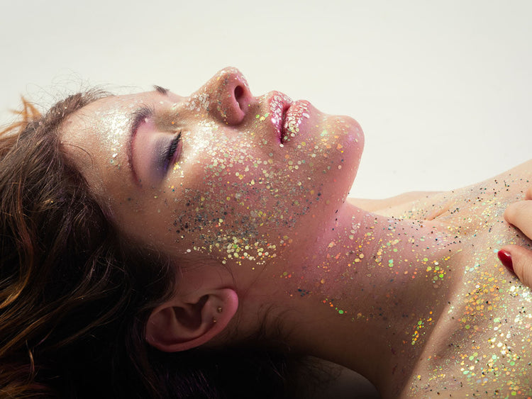 Woman with glitter on face, embodying beauty and rejuvenation from ORMUS alchemical topical support.